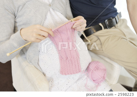 Pregnant women knitting at the window side 2598223