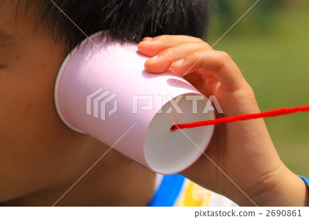 Boy listening on a tin can phone 2690861