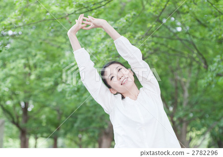 A woman taking a deep breath in trees A woman taking a deep breath in trees 2782296
