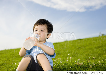 A 3-year-old boy drinking water under blue sky 2939742