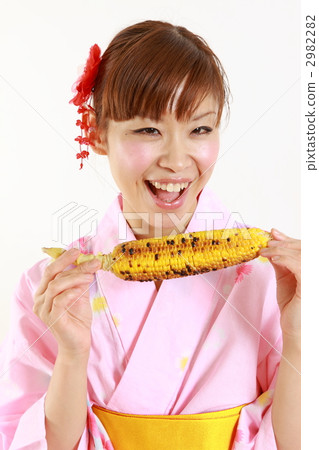 A young woman in a yukata with baked corn 2982282