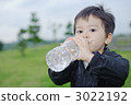 Three-year-old boys drinking water on the lawn 3022192