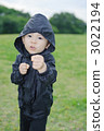 Three-year old boy taking a fighting pose on the lawn 3022194