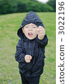 Three-year old boy taking a fighting pose on the lawn 3022196