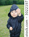 Three-year old boy taking a fighting pose on the lawn 3022197