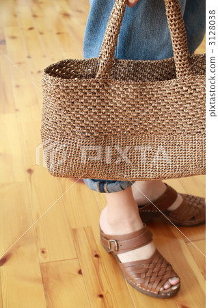 A woman holding a hand-woven raffia bag 3128038