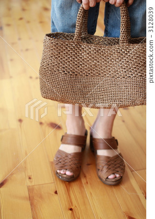 A woman holding a hand-woven raffia bag 3128039