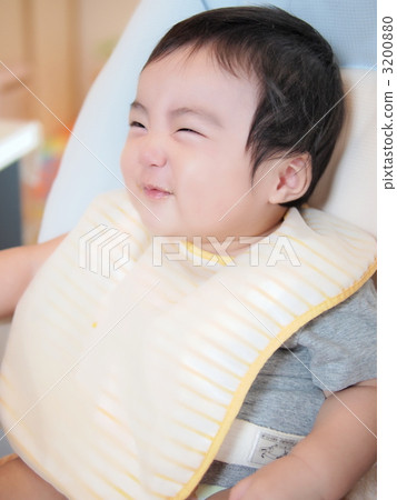 有一張微笑的面孔的嬰孩在嬰兒食品期間 有一張微笑的面孔的嬰孩在嬰兒食品期間 3200880