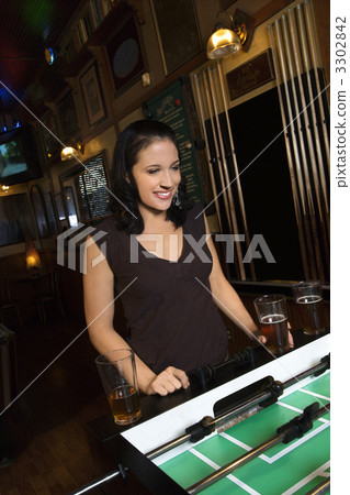 Young woman playing foosball. Young woman playing foosball. 3302842