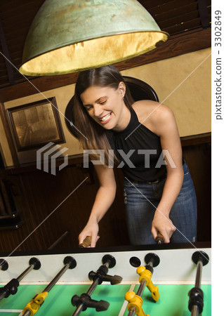 Young woman playing foosball. Young woman playing foosball. 3302849