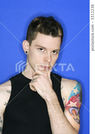 Man with pierced ear and tattoo. 3311236
