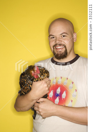 Smiling man holding chicken. 3312111