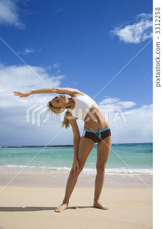 Woman stretching on beach. 3312258
