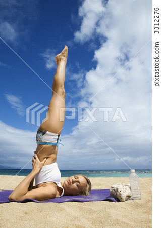 Woman doing yoga on beach. 3312276
