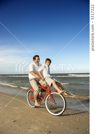 Dad riding red bicycle with son on handlebars. Dad riding red bicycle with son on handlebars. 3317222