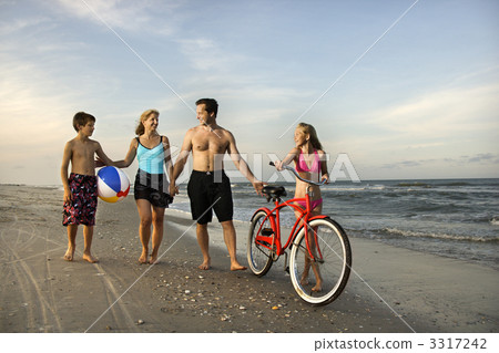 Family walking down the beach. 3317242