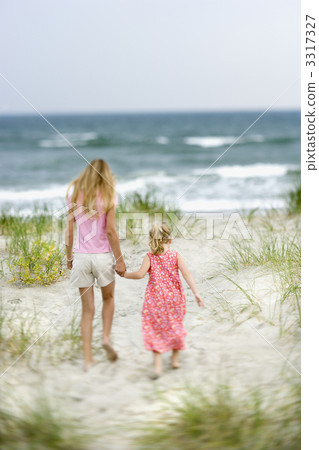 Sisters walking on beach. 3317327