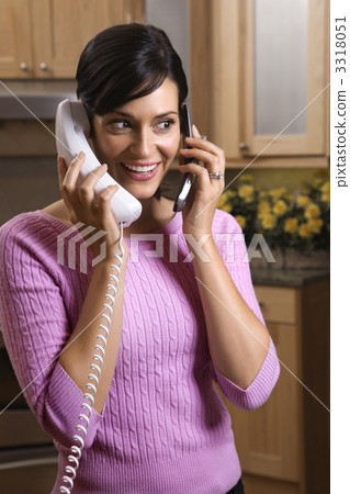 Woman Talking on Two Telephones 3318051