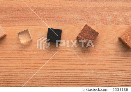 A wooden table lined with blocks of various materials. A wooden table lined with blocks of various materials. 3335186