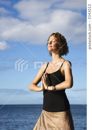 Woman meditating by ocean. 3343013