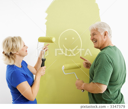 Couple laughing at smiley face painting. Couple laughing at smiley face painting. 3347379