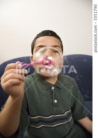 Boy blowing bubbles. Boy blowing bubbles. 3351790