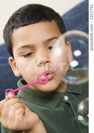 Boy blowing bubbles. 3351791