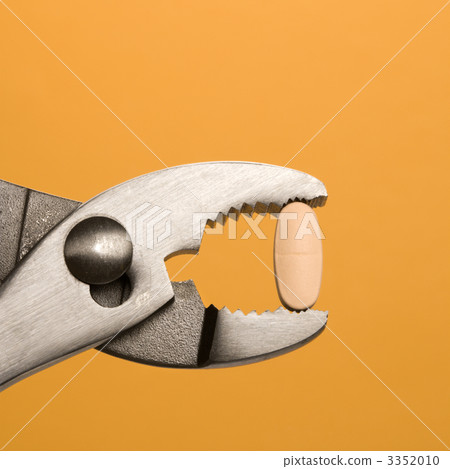 Pill Gripped With Pliers. Isolated Pill Gripped With Pliers. Isolated 3352010
