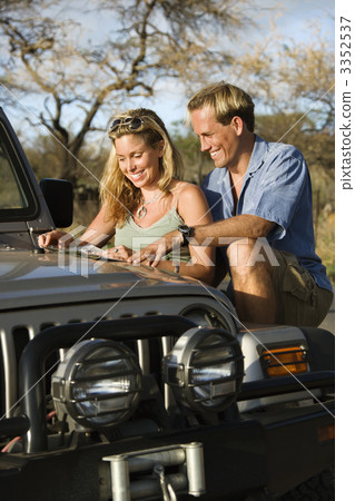 Couple With Map on Car Hood Couple With Map on Car Hood 3352537