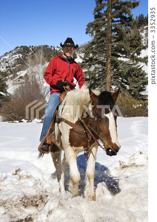 Man horseback riding in snow. 3352935