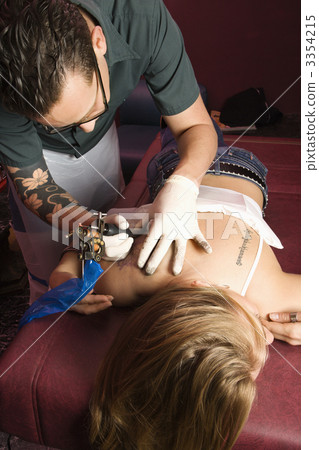 Man tattooing woman. 3354215