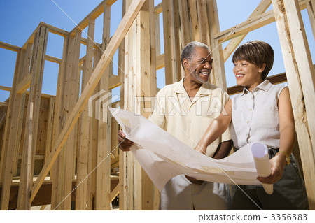 Couple Holding Building Plans on Construction Site Couple Holding Building Plans on Construction Site 3356383
