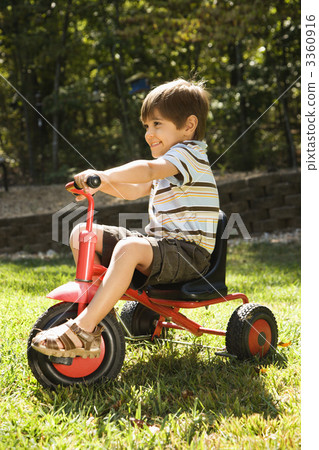 Boy riding tricycle. Boy riding tricycle. 3360916