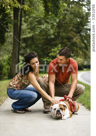 Couple petting dog. 3361098