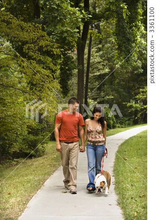 Couple walking dog. 3361100