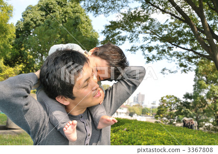 A parent and child giving a piggyback ride in the park A parent and child giving a piggyback ride in the park 3367808