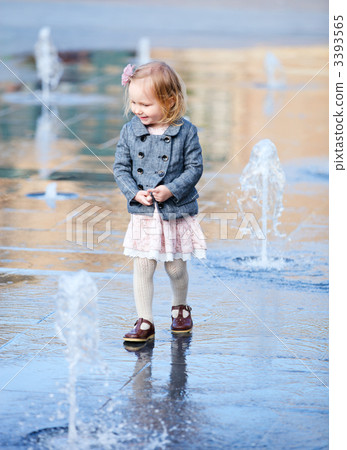 Little girl playing in street fountain 3393565