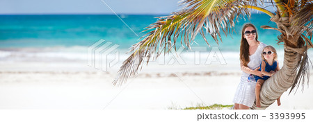 Mother and daughter sitting on palm 3393995