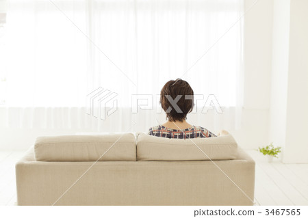 A woman sitting on a sofa in the living room A woman sitting on a sofa in the living room 3467565