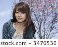 A woman looking at the front of a cherry tree 3470536