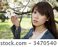 A woman looking at a cherry tree in her hand 3470540