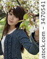 A woman looking at a cherry tree in her hand 3470541