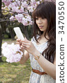 A woman taking cherry blossoms on a smartphone 3470550