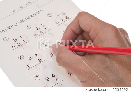 A hand scoring a test with a red pencil A hand scoring a test with a red pencil 3535392