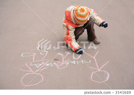 Boy sketches by chalk on asphalt 3541689
