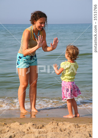 Mother plays with daughter on beach 3553766