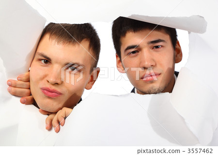 Two young men looking out in hole in paper 3557462