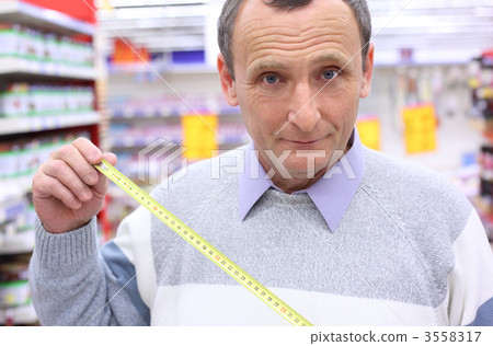 elderly man in shop with  roulette in hands 3558317