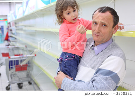 elderly man at empty shelves in shop with child on hands elderly man at empty shelves in shop with child on hands 3558381