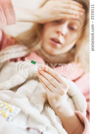 Young woman looking on thermometer Young woman looking on thermometer 3559111